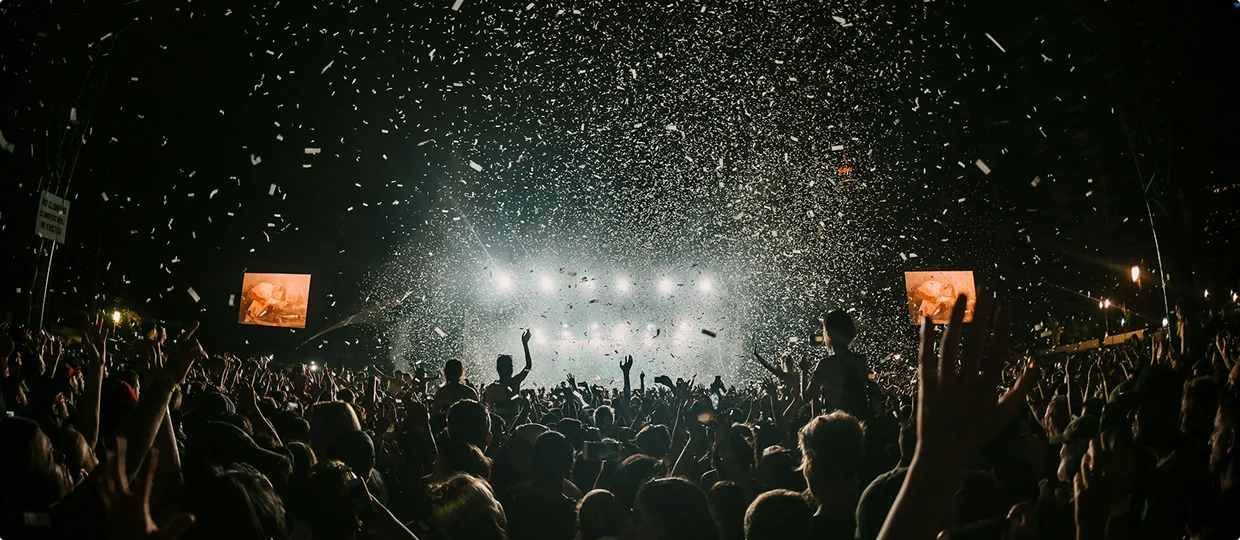 Groot publiek bij een live esports-evenement met felle podiumlichten en confetti die de arena vult.