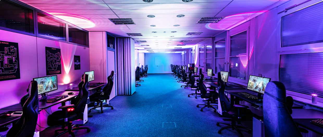Ruime esports-trainingsruimte uitgerust met meerdere gamestations, monitoren en professionele gamestoelen.